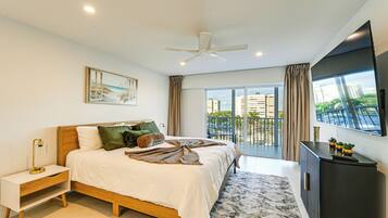 A modern bedroom with a bed, bedside table, and a large window with a view of buildings.