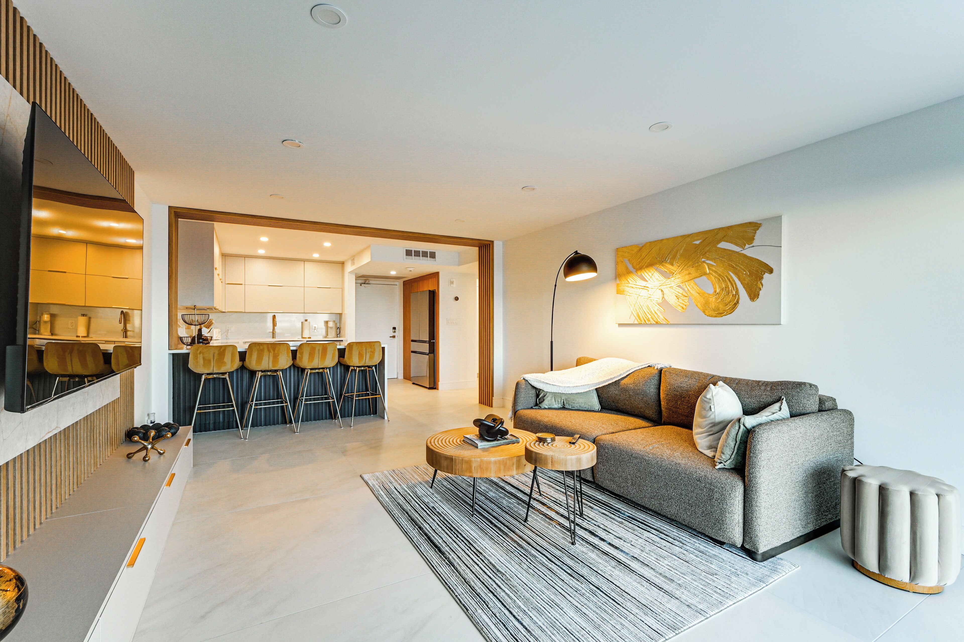 A modern living room with a sofa, coffee table, and a dining area with chairs.