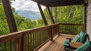 A wooden deck with a view of green mountains. - Mtn-view Deck! Maggie Valley Cabin, 8 Mi to Skiing (Maggie Valley)