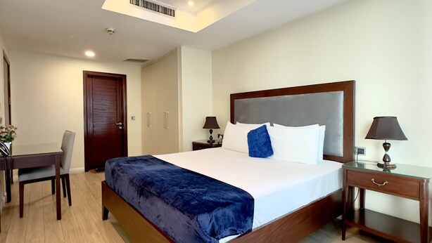 Una habitación de hotel con una cama de madera, un escritorio y una silla.
