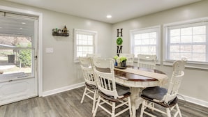 A dining room with a round table, white chairs, and a 'HOME' sign on the wall. - Secluded Getaway on 40 Acres in Lawrenceburg! (Lawrenceburg)
