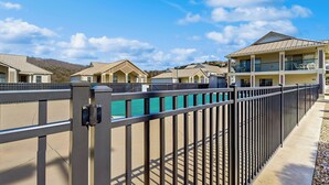 A gated residential area with multiple two-story houses, a clear sky, and a distant mountain range. - 2BR Poolside Condo w/ Sunroom, Close to Marina (Hollister)