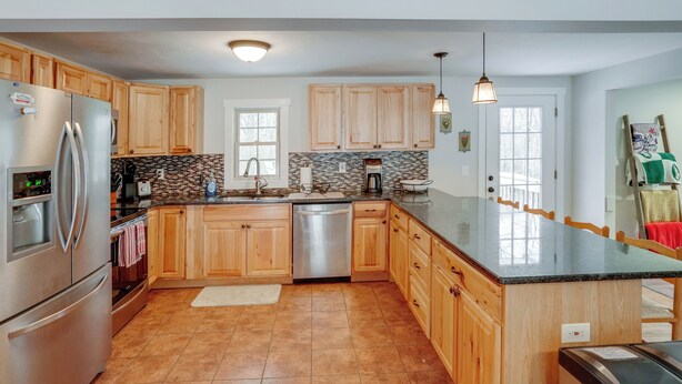 A modern kitchen with wooden cabinets, stainless steel appliances, and a large island. - 5 Mi to Mt Snow: Secluded Family Home w/ Game Area (West Dover)