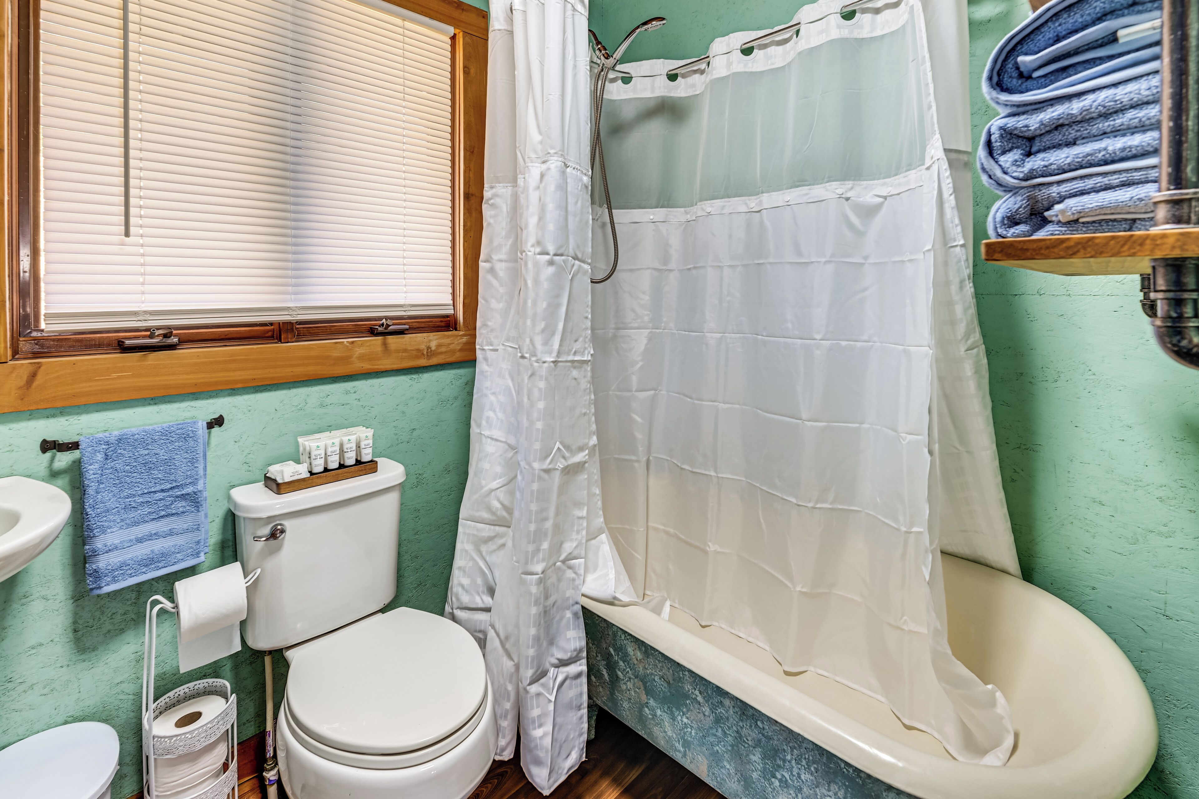 A bathroom with a toilet, sink, and shower curtain.