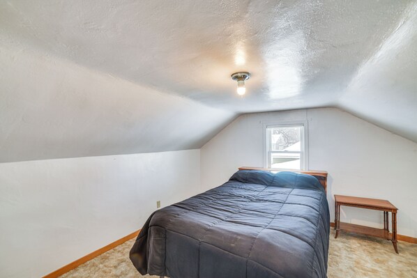 A bedroom with a bed, a nightstand, a window, and a ceiling light. - Spacious Retreat w/ Private Yard & Deck in Roscoe! (Roscoe)