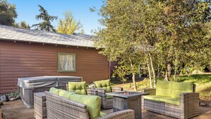 An outdoor patio area with wicker furniture, a hot tub, and a barbecue grill. - Buckthorn Beauty: Private Hot Tub & Lounge Space (Pine Valley)