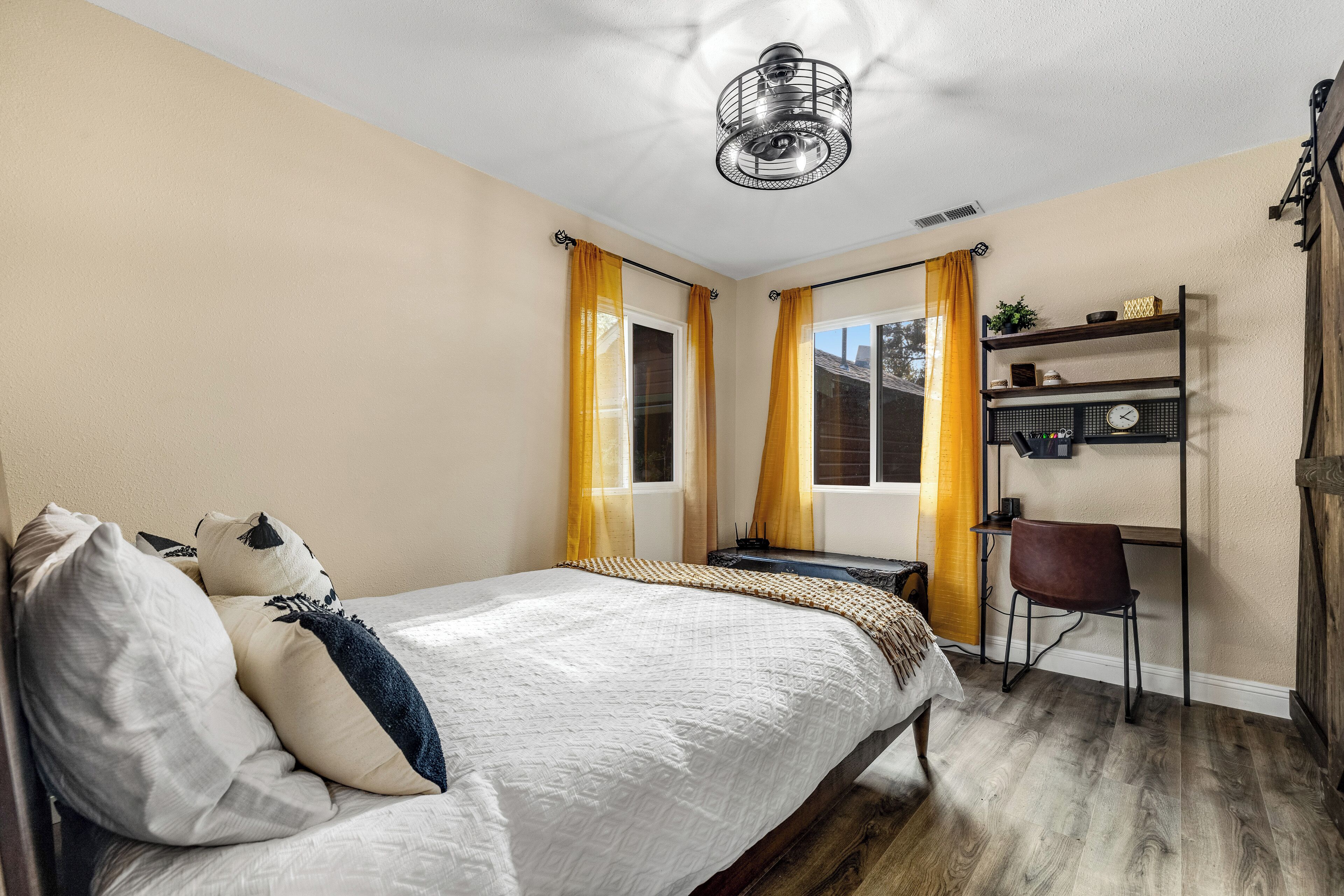 A bedroom with a bed, a desk, and a chair.
