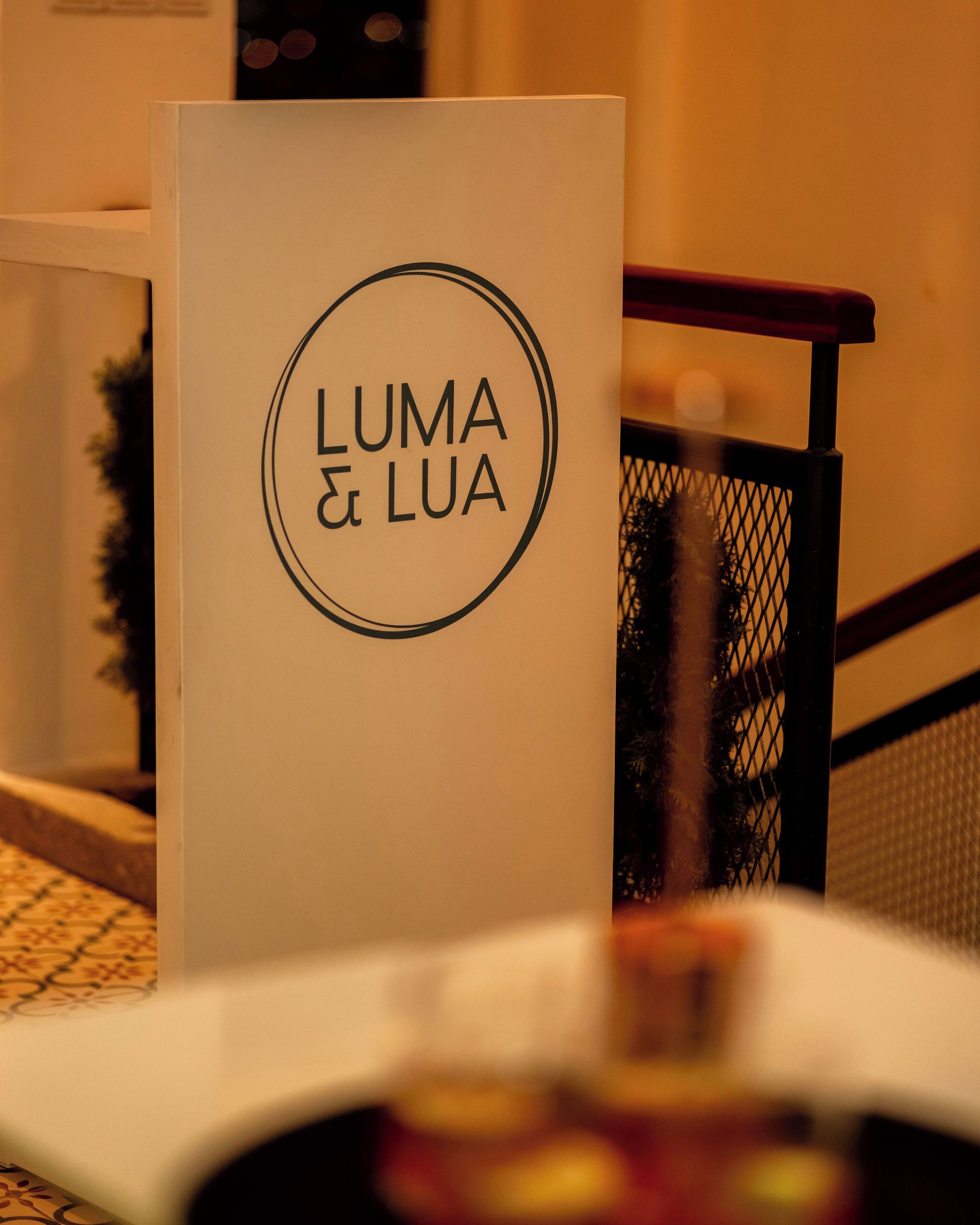 A sign with the text "LUMA & LUA" in a circular design.