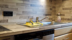 Een moderne keuken met een houten spatwand, een roestvrijstalen spoelbak en een Siemens vaatwasser.