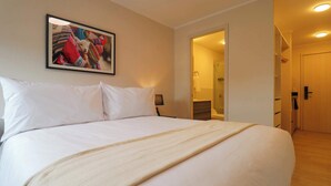 A large bed with white linens, a framed picture on the wall, and a wooden floor. - w Fascinating Loft in the Heart of Miraflores (Lima)
