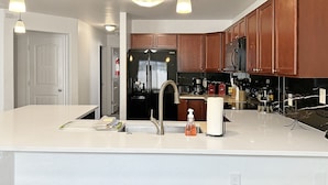 Una cocina moderna con una isla grande, electrodomésticos de acero inoxidable y armarios de madera.