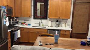 A modern kitchen with wooden cabinets, a built-in oven, a microwave, and a dishwasher. - Penny Lane-WALKING DISTANCE TO SQUARE & GROVE (Oxford)