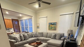 A spacious living room with a sectional sofa, a coffee table, and a ceiling fan. - Penny Lane-WALKING DISTANCE TO SQUARE & GROVE (Oxford)