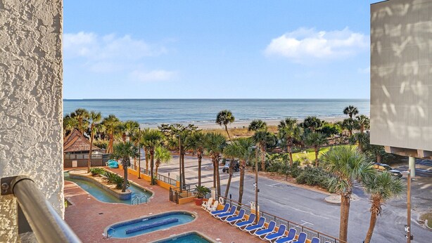 A resort with a pool, lounge chairs, and a view of the beach and ocean. - Beautiful, Quiet, Peaceful Studio (Myrtle Beach)