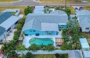 Une propriété résidentielle dotée d’une piscine, de plusieurs garages et d’un jardin bien entretenu.