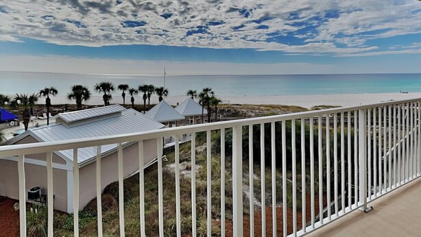 Ein Balkon mit Blick auf Strand und Meer.