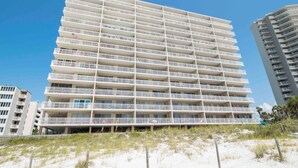Ein mehrstöckiges Hotel mit Balkonen in der Nähe eines Sandstrandes.