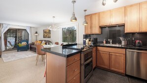 Een moderne keuken met houten kastjes, roestvrijstalen apparatuur en hanglampen.