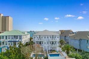 Een meerlaags woongebouw met een zwembad en balkons.