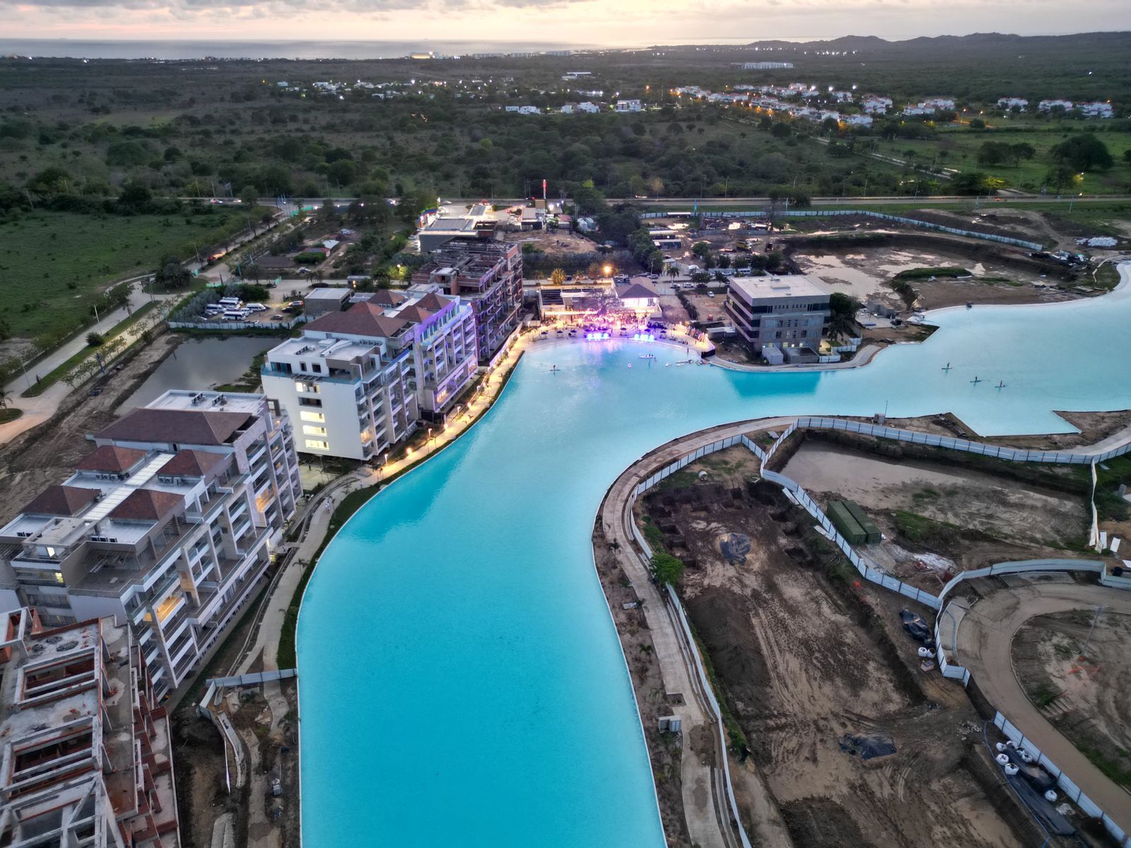 An aerial view of a coastal resort with a marina, buildings, and a large body of water.