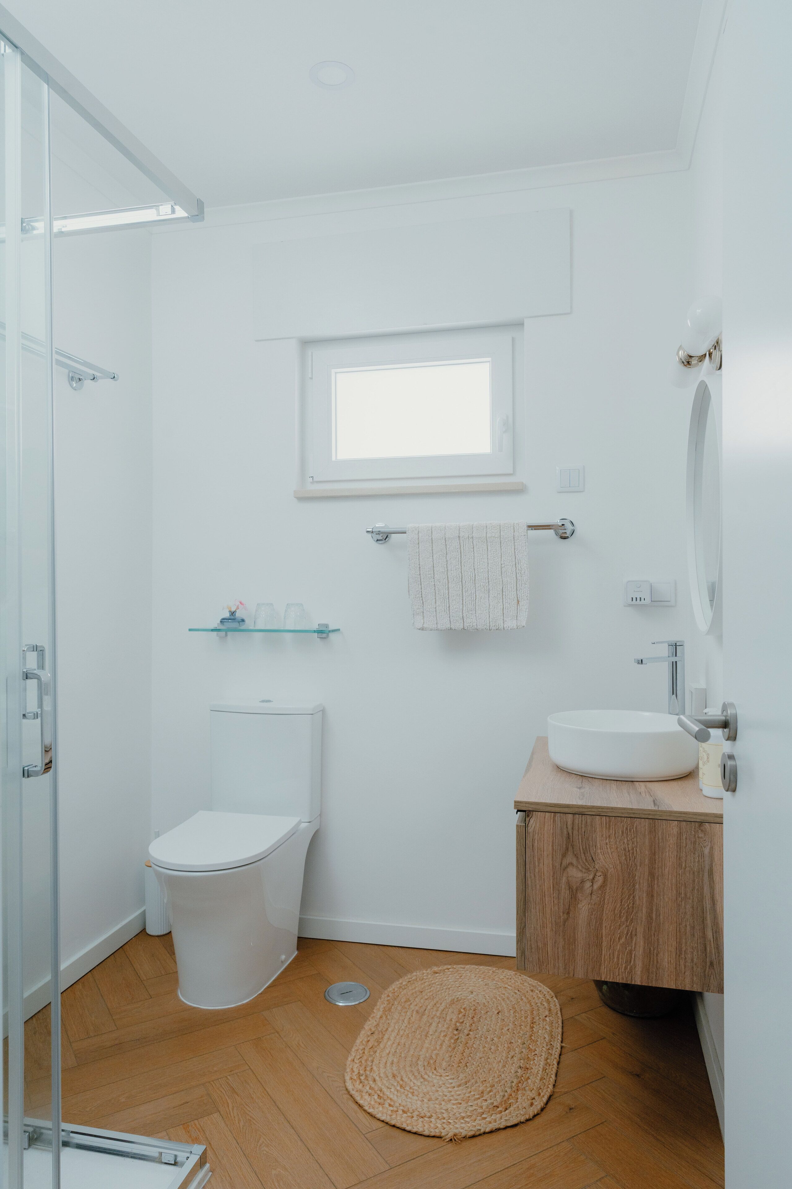 A modern bathroom with a toilet, sink, and shower.