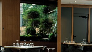 A restaurant with tables set for dining, a view of greenery outside, and a modern interior design. - La Suite   (Roanne)