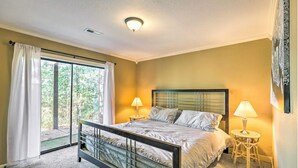 Un dormitorio con cama, dos lámparas de noche, una ventana con cortinas y una lámpara de techo.