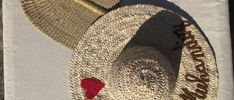 Un sombrero tejido con un parche en forma de corazón y el texto 'Happy Birthday' sobre una superficie de tela.