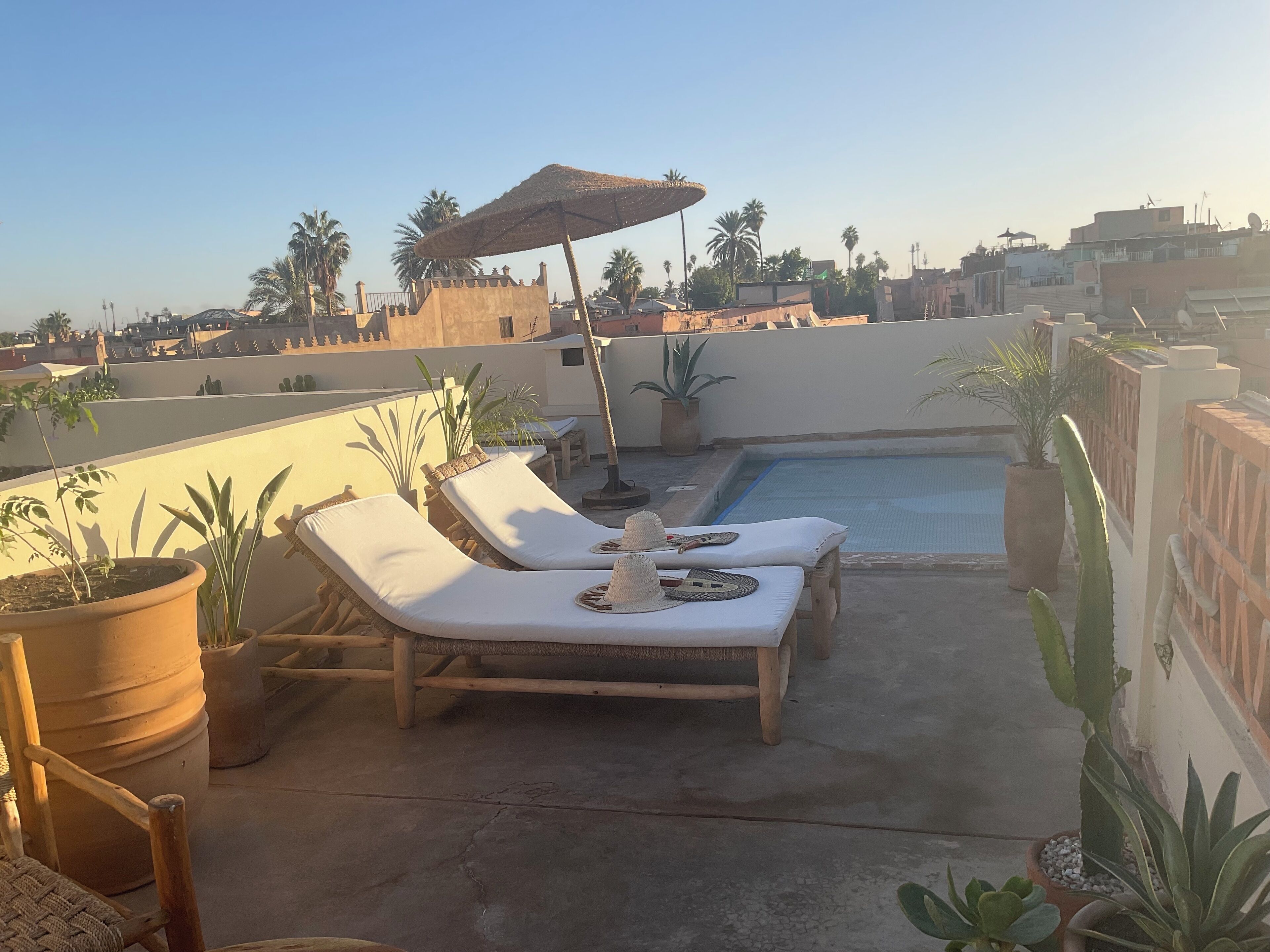 A rooftop pool area with lounge chairs and a small pool.