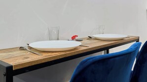 A dining table with two white plates, a fork, and a glass. - Baignoire Blanéo & Sauna, 10 minutes de la gare (Tourcoing)