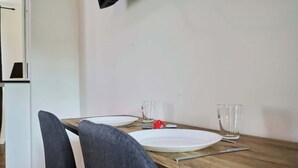 Een eettafel met twee witte borden, twee glazen en een lepel.