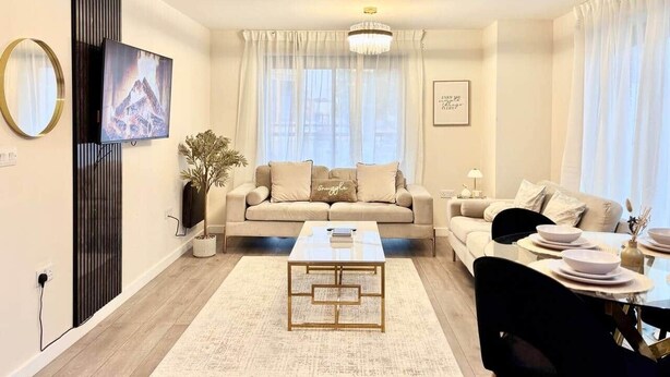 A modern living room with a sofa, coffee table, and dining area. - Modern 4-Bed House • Sleeps 9 •Free Parking, Leeds (Leeds)