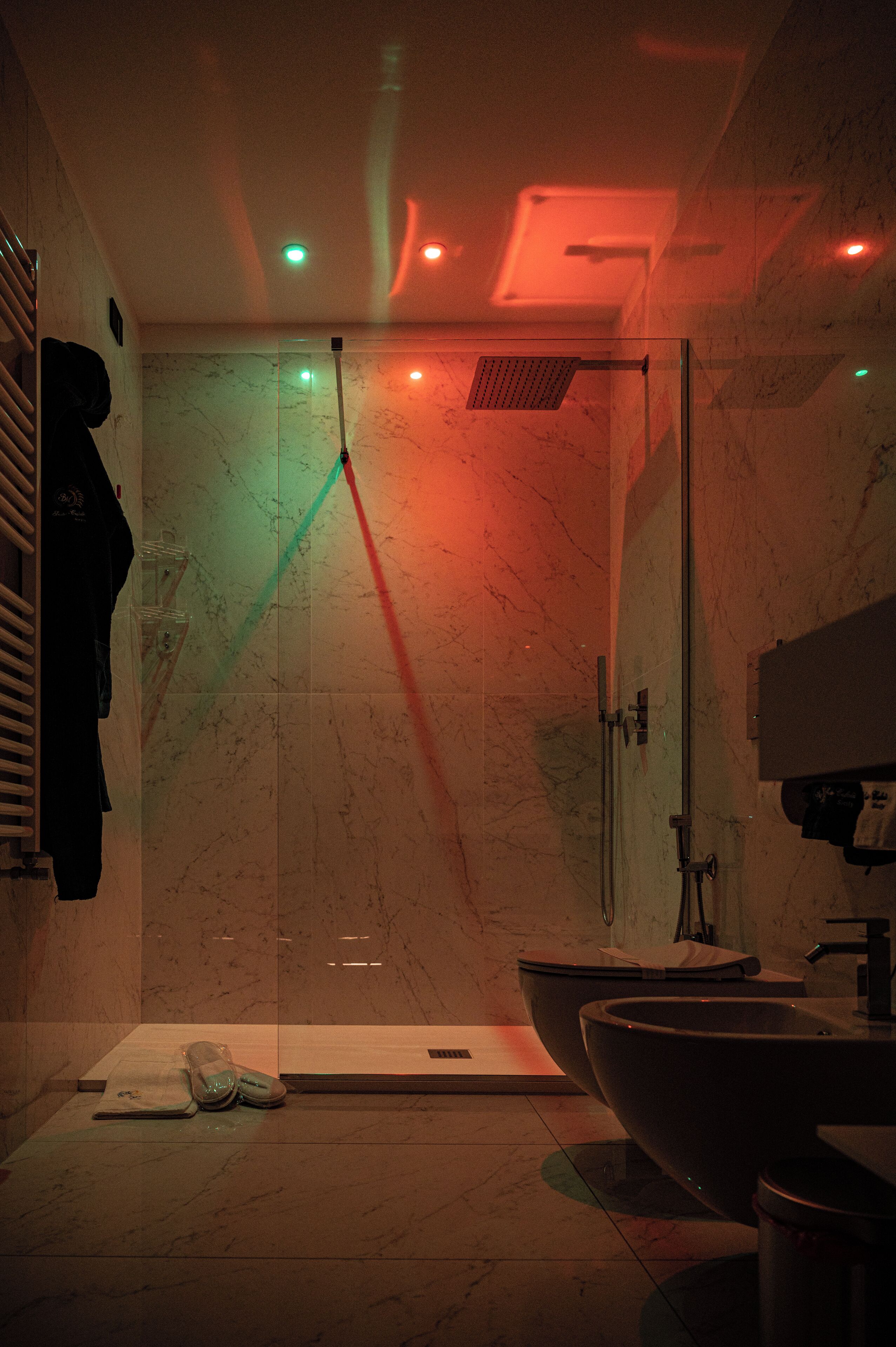 A modern bathroom with a glass-enclosed shower, a large sink, and a towel rack.