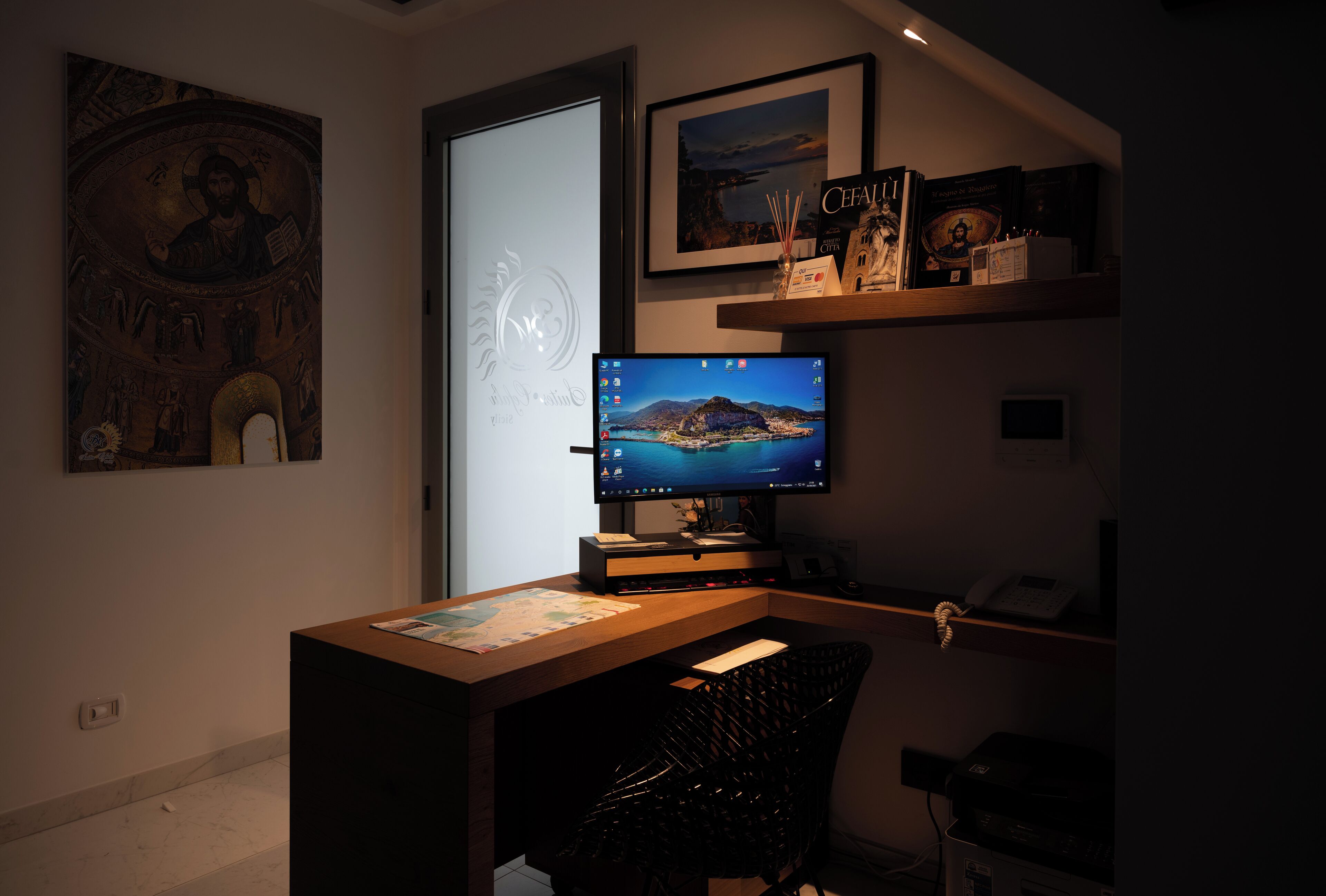 Une pièce comprenant un bureau, un ordinateur, une chaise, une bibliothèque et une porte.