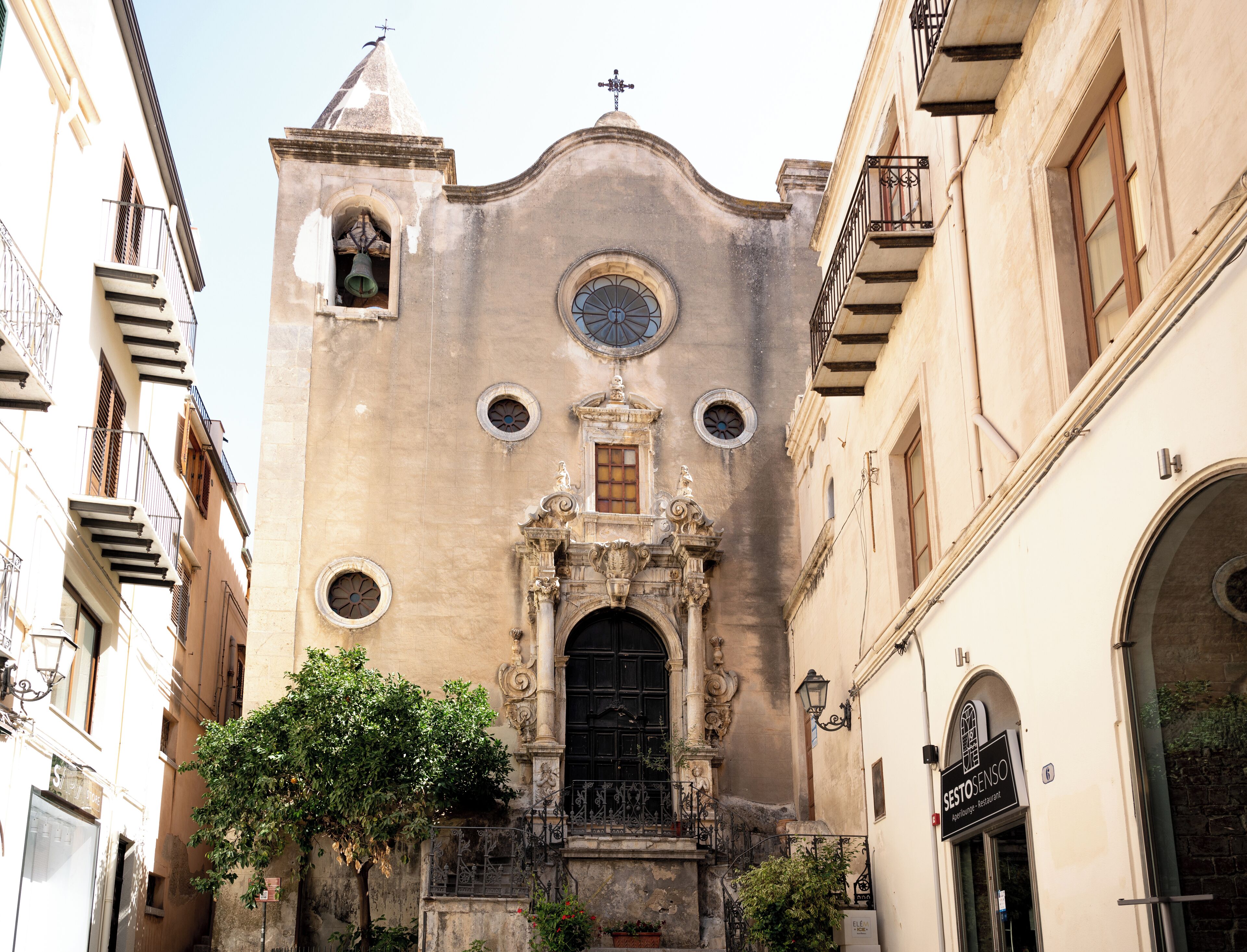 A historic building with a central entrance, ornate architectural details, and a bell tower.