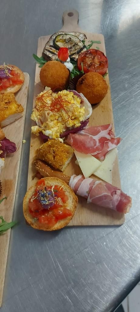 A wooden board with various food items including bread, eggs, cheese, and meat.