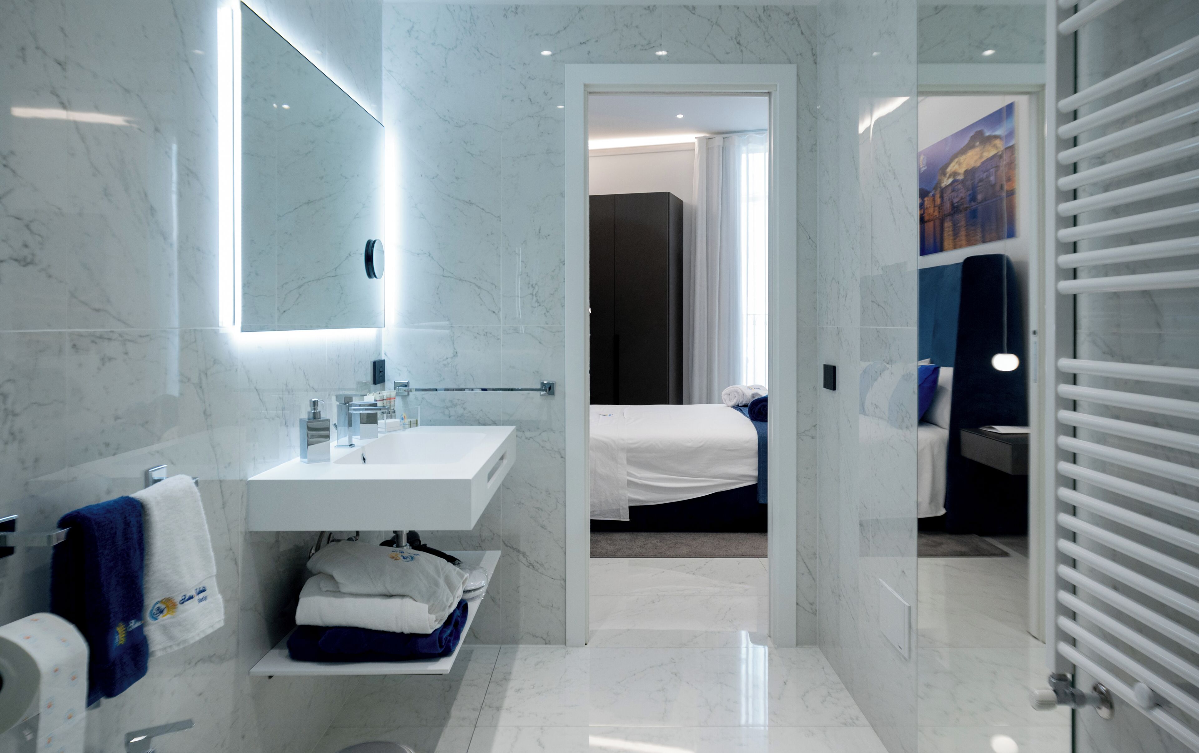 Une salle de bain moderne avec un lavabo en marbre, un miroir et un porte-serviettes.