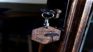 Ein Holzkügelschlüssel mit einem Etikett, auf dem 'UPHAMDONU RESIDENCES' steht.
