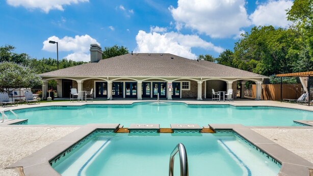 A swimming pool with a no diving sign, lounge chairs, and a covered seating area with a stone facade. - Modern North Austin Retreat by The Domain (Austin)