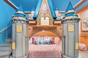 A bedroom with a castle-themed bed, a staircase, and a decorative wall with a 'Once Upon a Time' sign. - 7BR house sleeps 16 with private pool (Kissimmee)