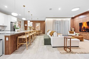 A modern kitchen with a central island, wooden bar stools, and pendant lighting. - 7BR house sleeps 16 with private pool (Kissimmee)