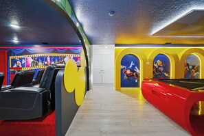 Een kamer met een pooltafel, een rode bank en een sterrenhemel op het plafond.