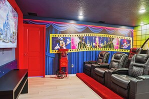A room with a red door, a popcorn machine, and a large animated character mural. - 10BR house with private pool and game room (Clermont)