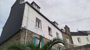 A two-story building with stone walls and a white facade, featuring multiple windows with shutters. - Cosy T2 with view in Morlaix between station and town center (Morlaix)