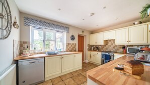 A kitchen with a dishwasher, stove, microwave, and wooden countertops. - Sunnydene - sleeps 6 guests  in 3 bedrooms (Brancaster Staithe)