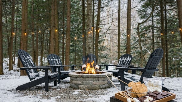 A cozy outdoor setting with a fire pit, three Adirondack chairs, and a snack tray with marshmallows and chocolate. - Mountain Moose Chalet- indoor hot tub, FirePit (Killington)