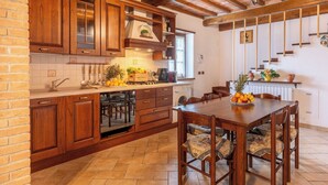 Una cocina con armarios de madera, una mesa de comedor y sillas.