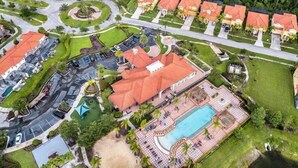 Luftaufnahme eines Resorts mit mehreren Gebäuden, einem Swimmingpool und angelegten Grünflächen.