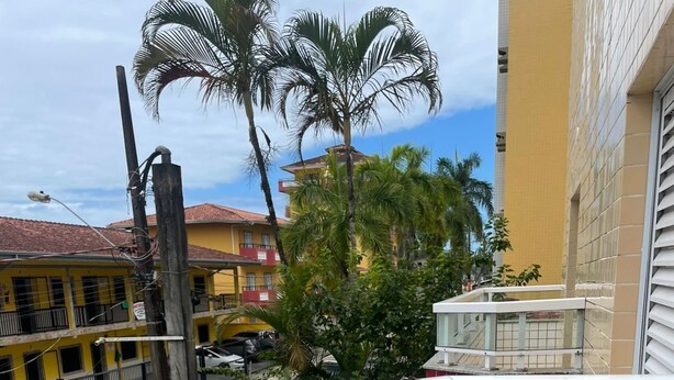 A balcony with a tiled floor and a railing. - Beachfront apartment (Ubatuba)
