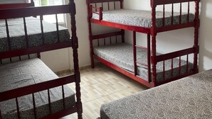 A room with three bunk beds, a ceiling fan, and a window with a view of the outside. - Beachfront apartment (Ubatuba)